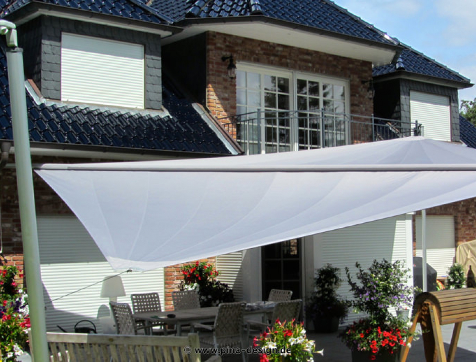 Sonnensegel elektrisch Trittau 3M / 1W II. Sonnensegel elektrisch Trittau 3M / 1W II. graues Segel vor einem Haus