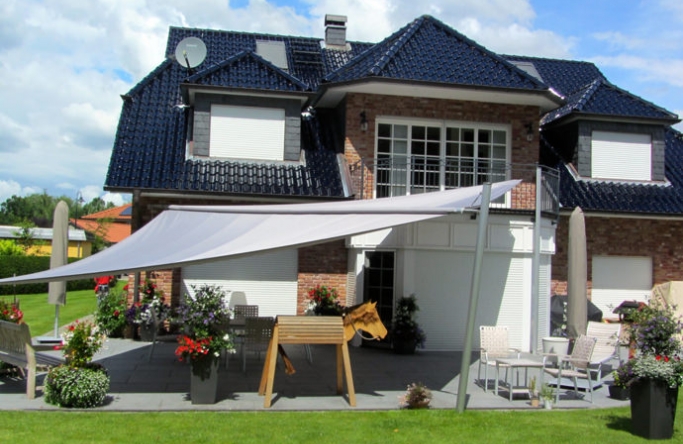 Sonnensegel elektrisch Trittau 3M / 1W I. graues Segel vor einem Haus